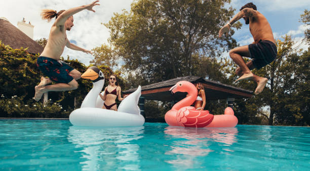 istock Young friends having fun in a swimming pool 984802896