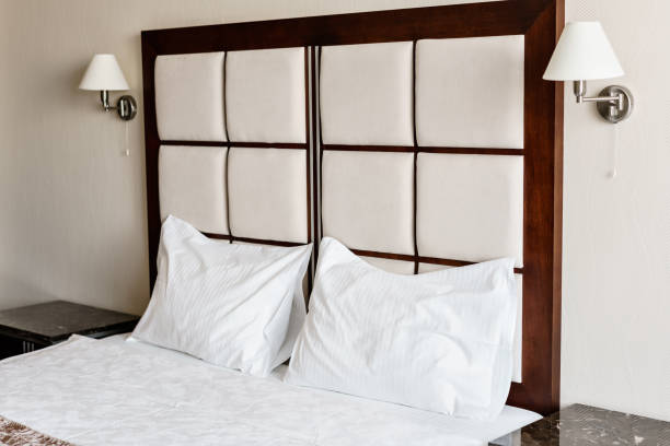 istock Modern double bedroom. Comfortable soft white pillows on a bed. Inside rooms of a apartment or hotel. 984813186