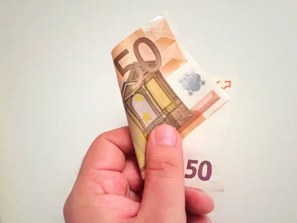 Male hand holding a 50 euro banknote