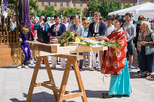 Ljubljana, Slovenia - Jun 23, 2018: The Shinto priestess leading the Japan day festival inviting gods to portable shrine and offering additionally to rice, salt and sake, the best local food that will be offered to the gods during the festival in accordance with the Japanese tradition. The festival is the first in Ljubljana, Slovenia, next to Berlin in Germany and Montréjeau in France. Portable Mikoshi shrine is brought from the Japanese Kasuga Shrine and is located in Europe. Local people and some Japanese carry the portable shrine (mikoshi) in the streets to bring good fortune to local businesses and residents.
