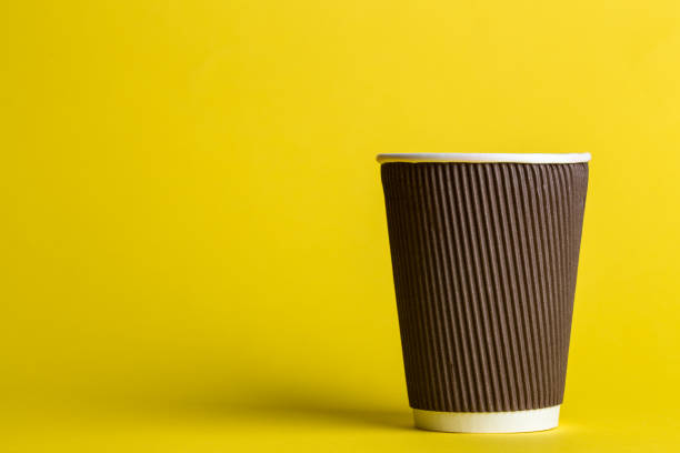 istock coffee to go in a disposable cup on a yellow background 984825120