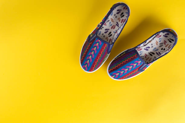 istock bright multi-colored women's shoes on a yellow background. 984825930
