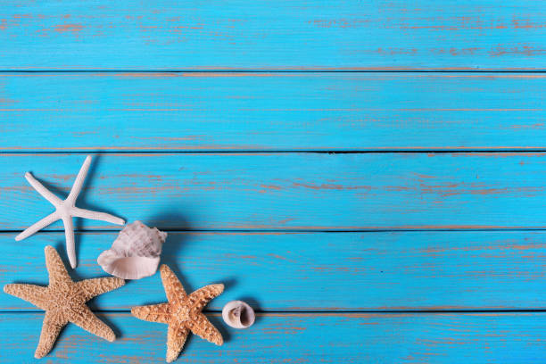 istock Summer beach seashore background starfish blue old wood paint peeling 984839892