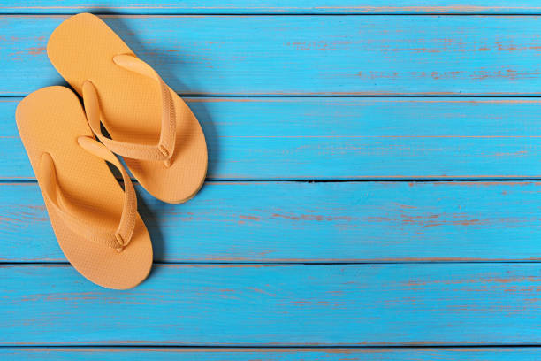 istock Flip flops on old weathered blue beach wood 984840618