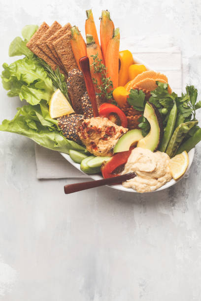 hummus dip árabe vegetariana con verduras y diferentes snacks sobre un fondo claro. concepto de alimento vegano saludable. - avocado lemon snack cracker fotografías e imágenes de stock