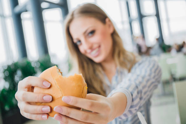 istock Happy woman holding a burger 984851852