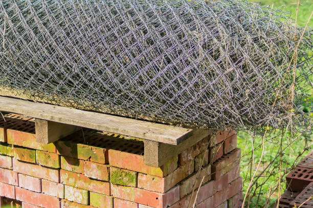 istock Pile of bricks and Rolls of wire mesh steel for construction outdoors on courtyard 984852040