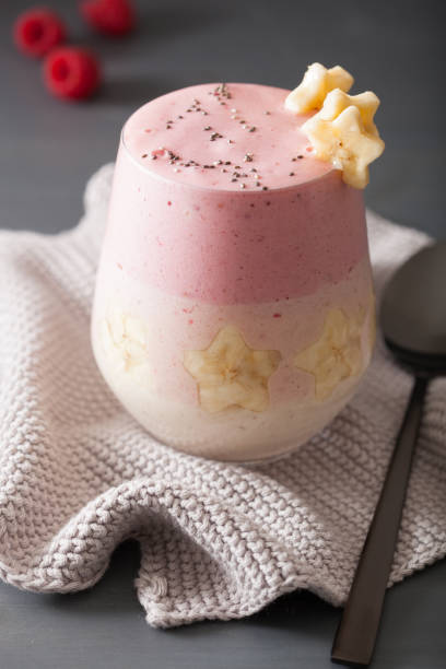 healthy layered raspberry banana smoothie in glass