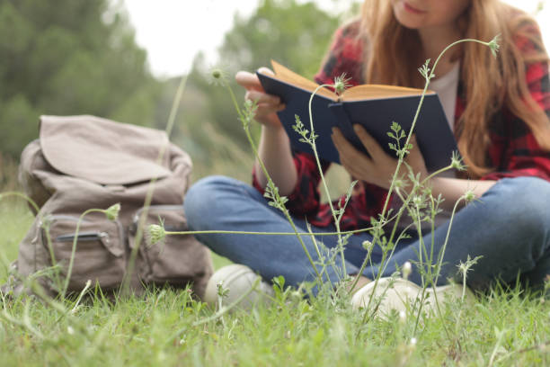 istock young girl reading book at park 984859110