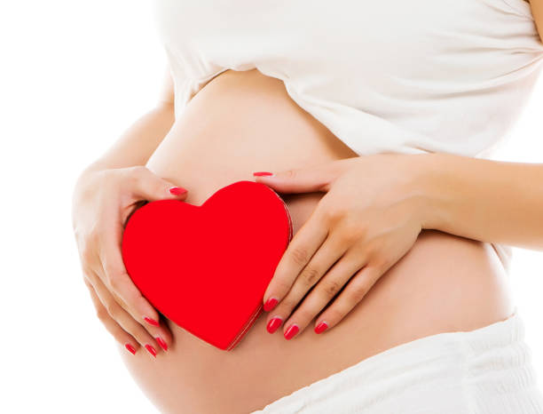 istock Pregnant woman with red heart 984873698