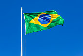Flag of Brazil waving in the wind against the sky