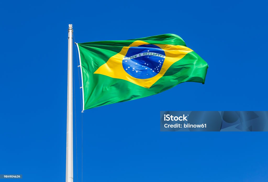 Flag of Brazil waving in the wind against the sky Flag of Brazil waving in the wind against the blue sky Brazil Stock Photo