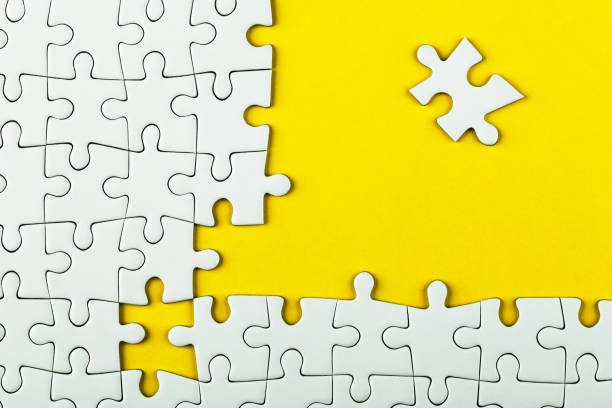 istock White details of puzzle on yellow background 984905046