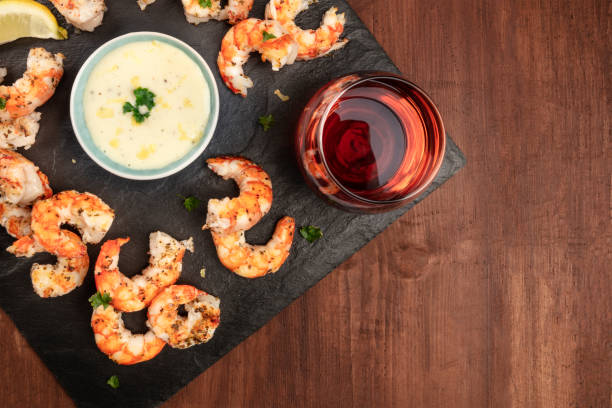 obenliegende foto von teller mit gekochten garnelen auf einem dunklen hintergrund der rustikalen, mit einer sauce und einem glas wein, mit textfreiraum - prepared shrimp prawn large grilled stock-fotos und bilder