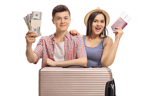 Teenage tourists with bundles of money and a passport isolated on white background