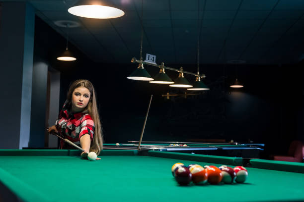 istock Pretty woman with cue starting play billiard 984966708