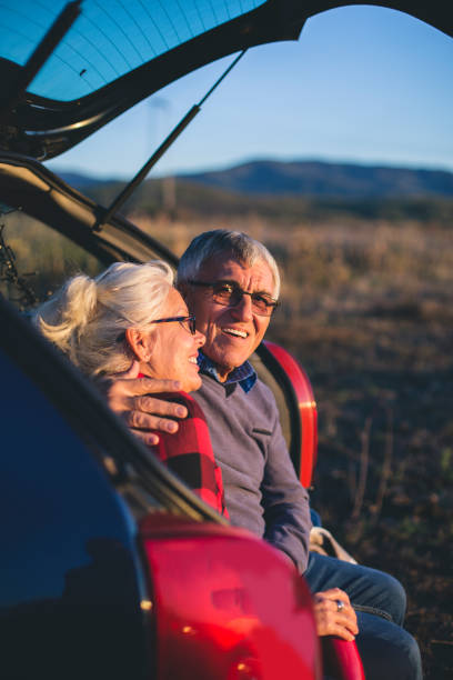 istock Senior couple sit in open car trunk before a hike 984971816