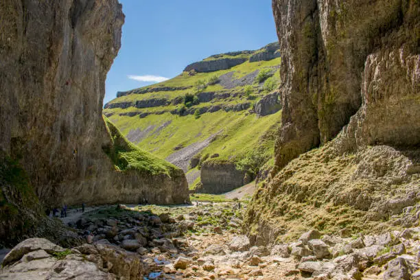 Gordale Scar is a limestone ravine in the Yorkshire Dales National Park, England. It contains two waterfalls and has overhanging limestone cliffs over 100 metres high