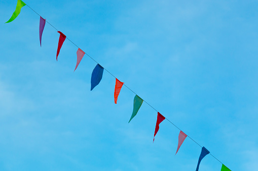 Coloridos banderines colgando con la cuerda contra el cielo azul. photo