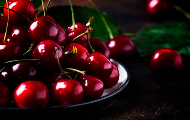istock Red sweet cherries on brown table 984973750