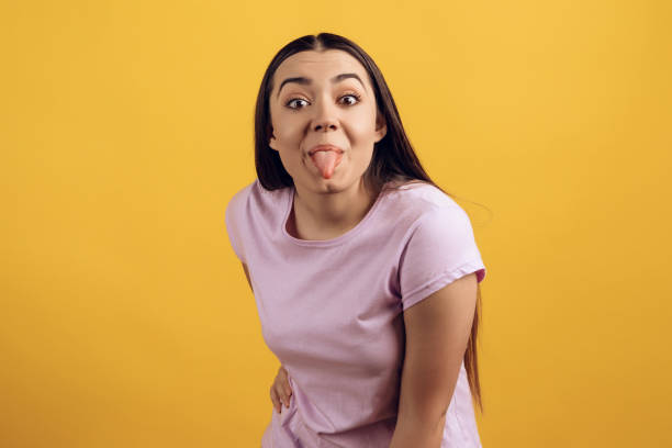 istock Young joyful girl shows tongue. 984974302