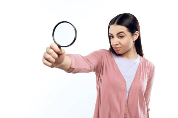 istock Young girl watches through magnifying glass. 984982220