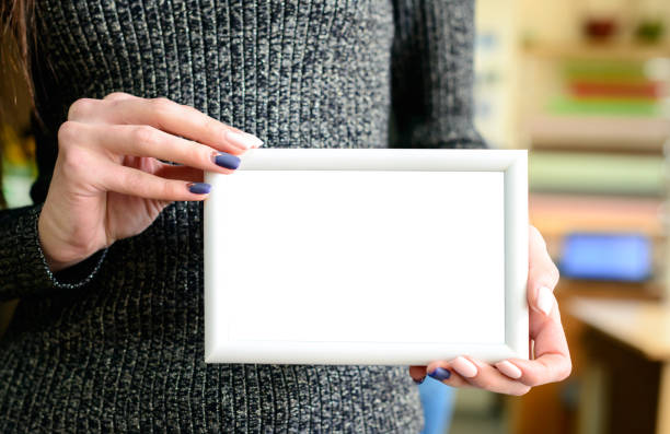 istock White mock up frame in woman hands 984982756