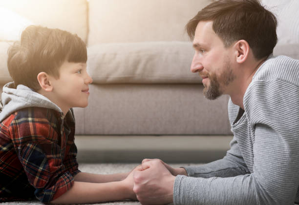 istock Side view of handsome father and son looking at each other 984983160