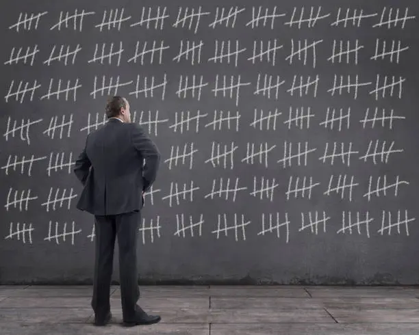 Photo of Businessman with Tally Marks on the Wall