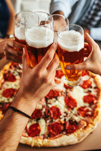 Close up shot of glasses of beer and pizza