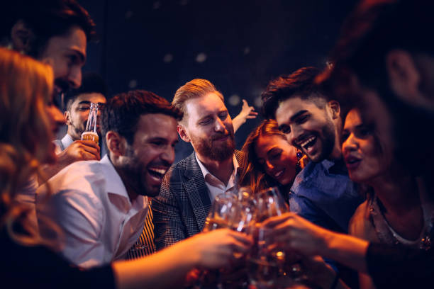 Here's to good times ! Group of friends toasting at a party nightlife stock pictures, royalty-free photos & images