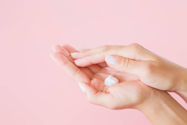 istock Young, perfect, groomed woman's hands using moisturizing, natural herbal cream. Care about clean, soft and smooth body skin. Beauty concept. Pink background. 984992658