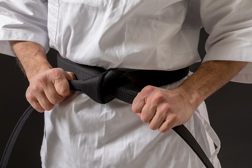 White judo, aikido, or karate belt, tied in a knot on white kimono