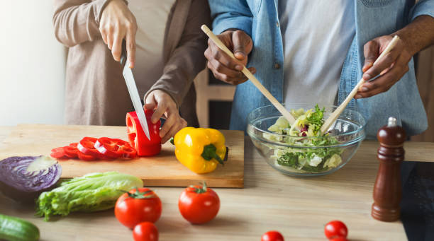 istock Black couple preparing vegetable salad together 984996460
