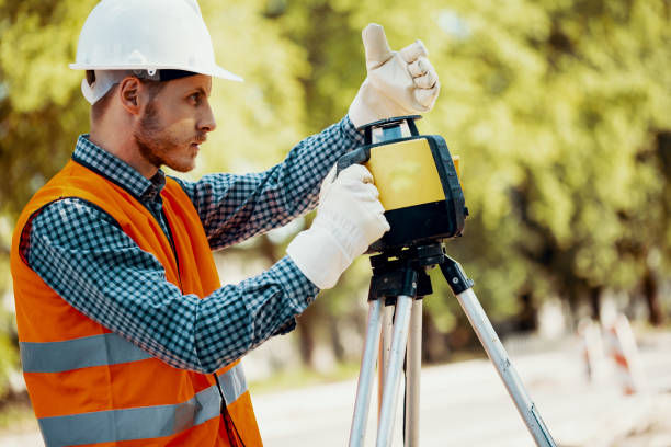 istock Engineer in uniform and white helmet using professional equipment during roadworks 985000492