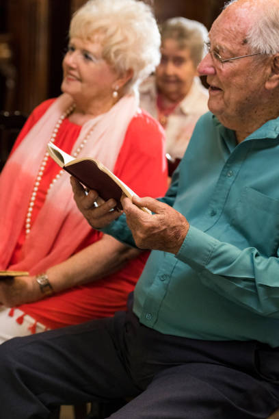 istock Senior man singing in church from a psalms book 985001722