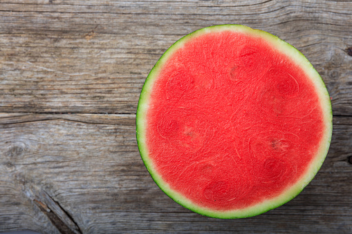 Half seedless watermelon on a wooden table - top view
