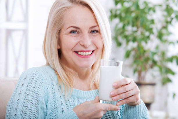 istock Happy middle aged woman drinking milk 985002824
