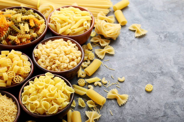 istock Different kinds of pasta in bowls on grey table 985005216