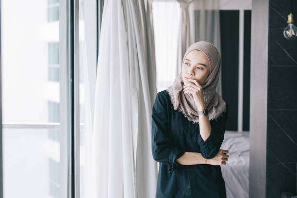 istock Woman looking out of window 985006510