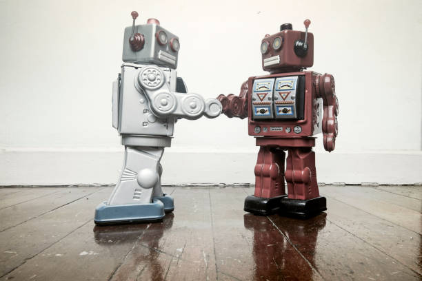 istock two vintage robot shake hands on a old wooden floor 985012202