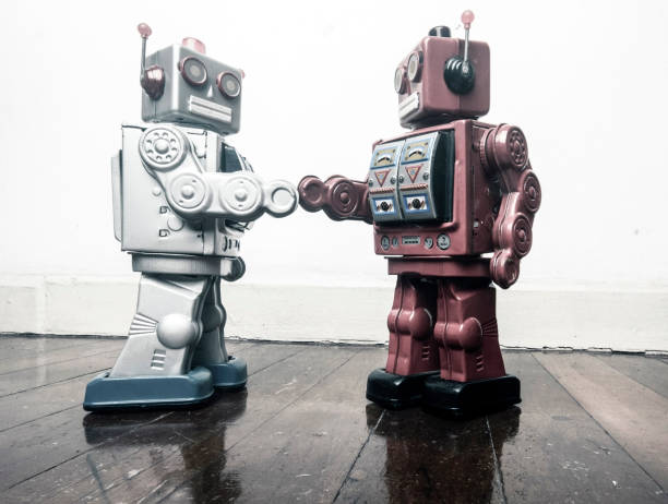 istock two vintage robot shake hands on a old wooden floor 985012204