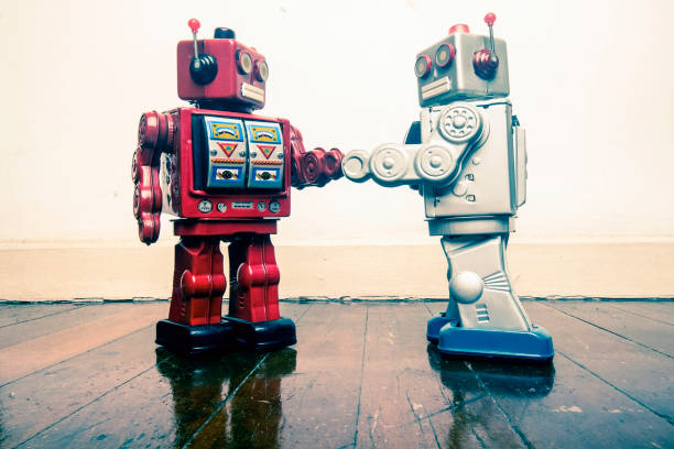istock two vintage robot shake hands on a old wooden floor 985012212