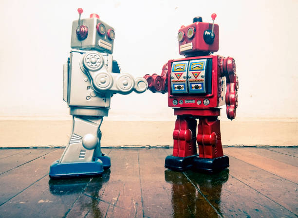 istock two vintage robot shake hands on a old wooden floor 985012228