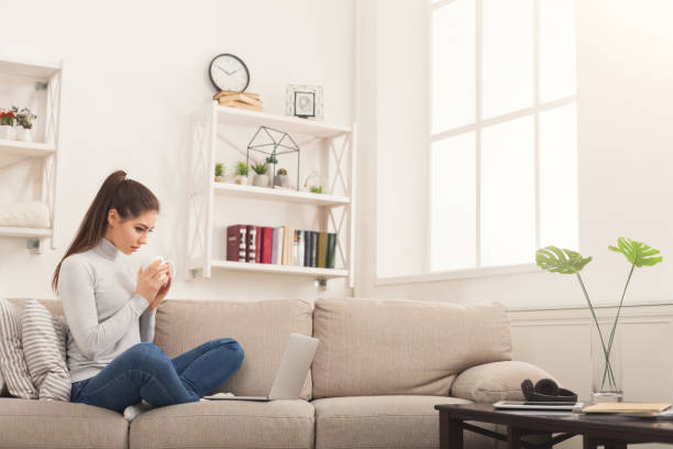 istock Young girl with laptop having coffee 985013254
