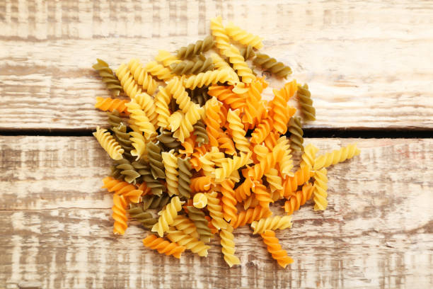 istock Spiral pasta on the brown wooden table 985014088