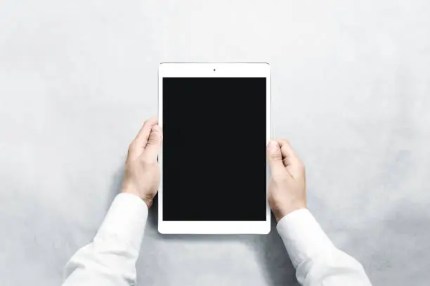 Photo of Hands holding blank vertical tablet mock up