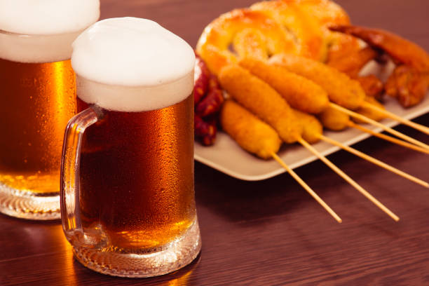 istock Traditional German food Beer Fest. Beer, baked chicken wings, popcorn, assortment, different sausages. 985019708