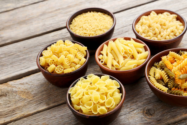 istock Different kinds of pasta in bowls on grey table 985020432