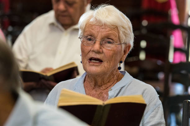 istock Senior woman singing in church 985023402